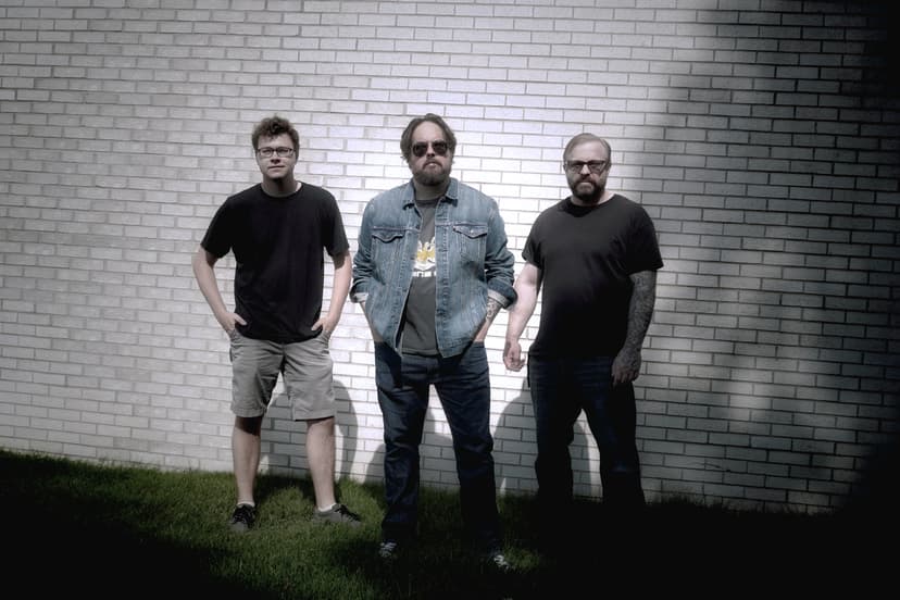 Sean Anthony Sullivan with band in front of brick wall.